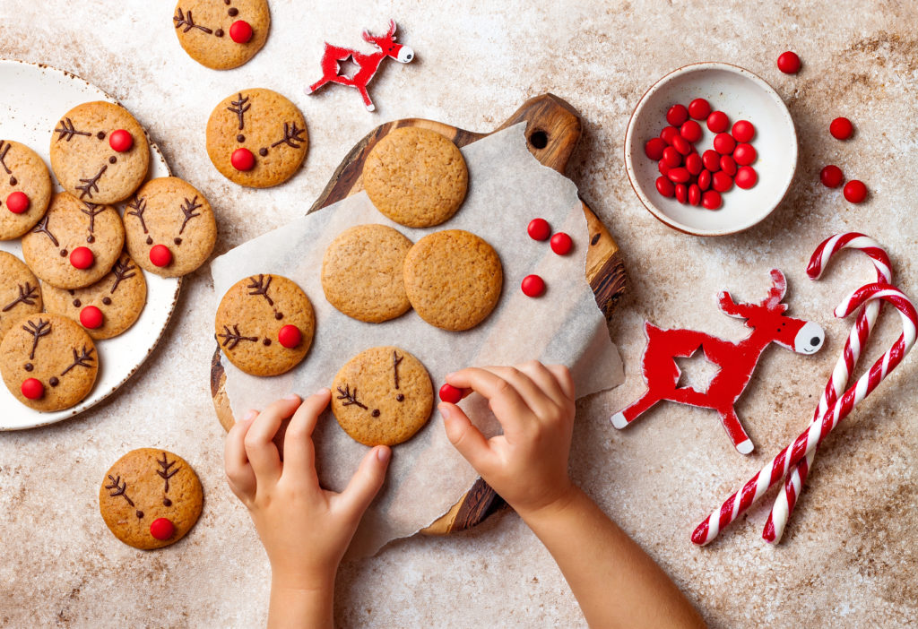 Image of child's hands decorating reindeer cookies